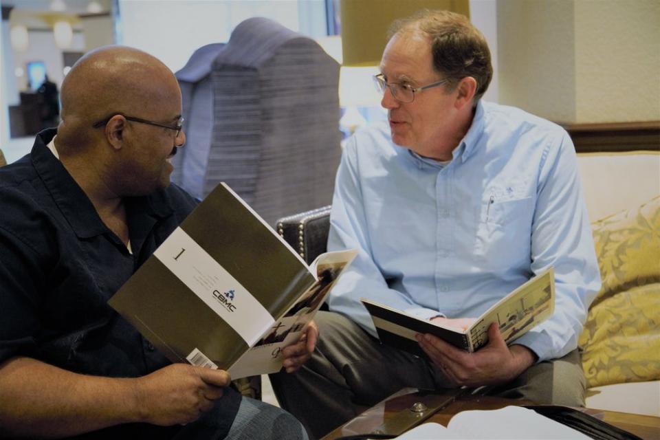 two men discussing OT with books